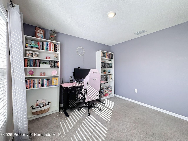 home office featuring carpet flooring and a textured ceiling