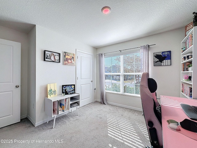 carpeted home office featuring a textured ceiling