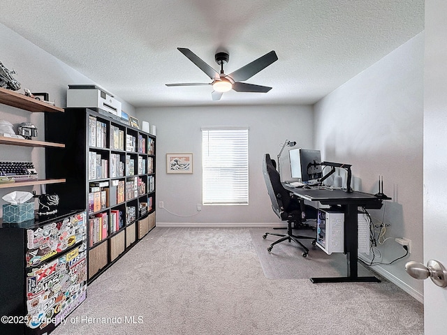 office space featuring light carpet, ceiling fan, and a textured ceiling