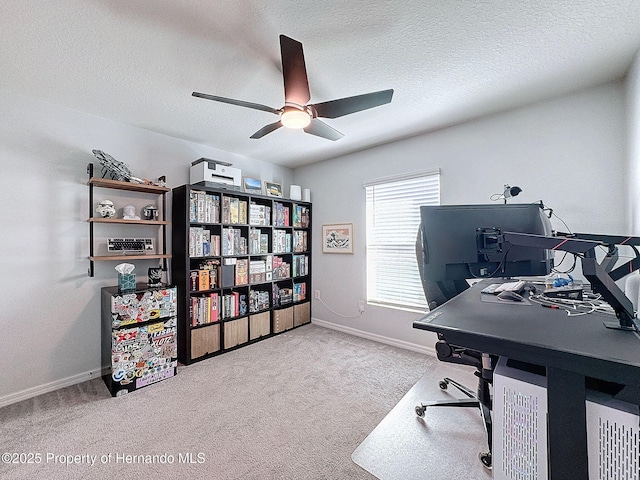 home office with a textured ceiling, ceiling fan, and light carpet