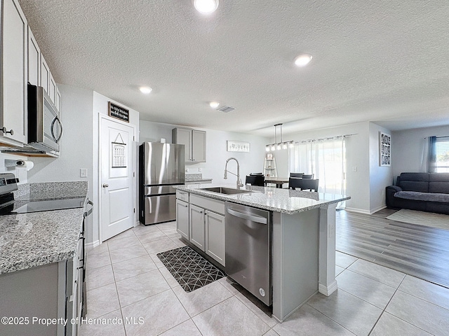 kitchen featuring appliances with stainless steel finishes, an island with sink, plenty of natural light, and sink