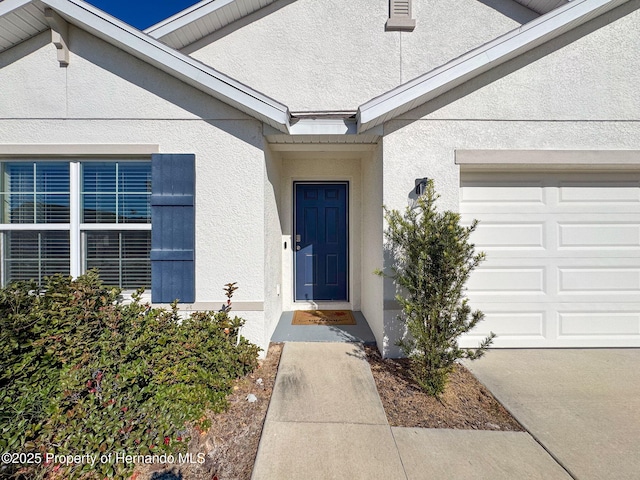3337 Autumn Amber Dr, Spring Hill, FL 34609 - doorway to property with stucco siding and an attached garage