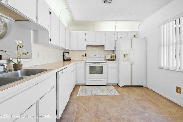 kitchen featuring backsplash, a textured ceiling, white appliances, sink, and white cabinets