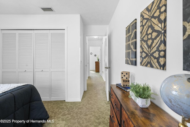 hall with a textured ceiling and light colored carpet