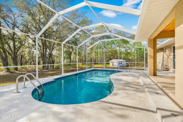 view of swimming pool featuring a patio and a lanai