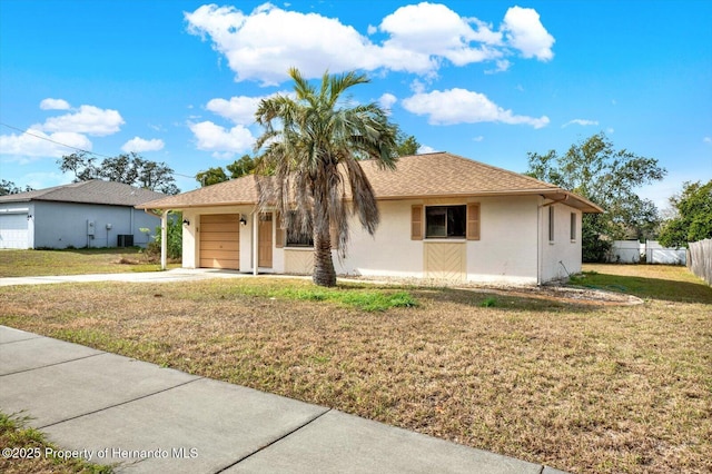 ranch-style home featuring a front yard, a garage, and cooling unit