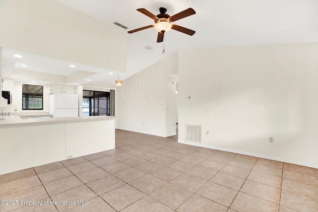 unfurnished living room with ceiling fan, sink, light tile patterned floors, and lofted ceiling