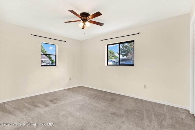 carpeted spare room featuring ceiling fan