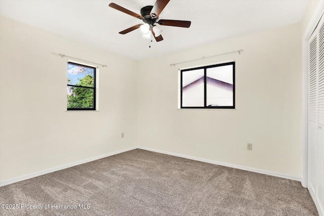 carpeted spare room featuring ceiling fan