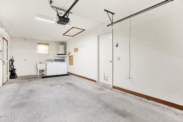 garage with washing machine and dryer, electric water heater, sink, and a garage door opener