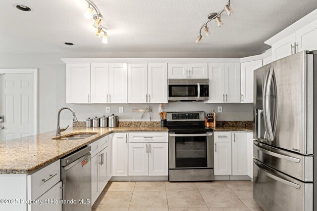 37351 Neighbors Path, Zephyrhills, FL 33542 - kitchen featuring kitchen peninsula, appliances with stainless steel finishes, light stone countertops, and white cabinets