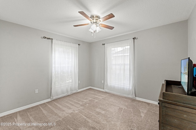 37351 Neighbors Path, Zephyrhills, FL 33542 - bedroom featuring multiple windows, a textured ceiling, ceiling fan, and light colored carpet