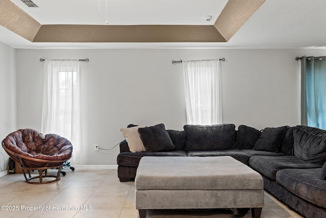 37351 Neighbors Path, Zephyrhills, FL 33542 - living room featuring light tile patterned flooring and a tray ceiling