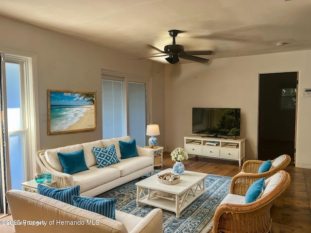 living room featuring ceiling fan and dark hardwood / wood-style flooring