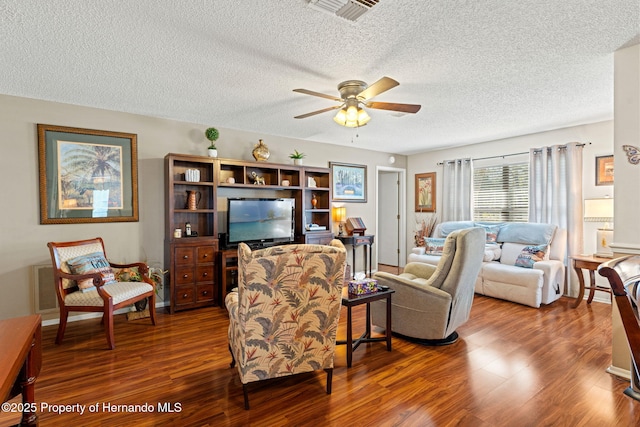 living room with a textured ceiling, hardwood / wood-style flooring, and ceiling fan