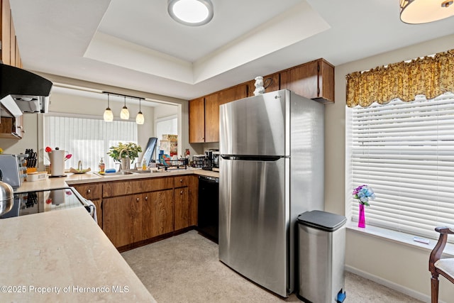 kitchen featuring a raised ceiling, hanging light fixtures, stainless steel fridge, black dishwasher, and range