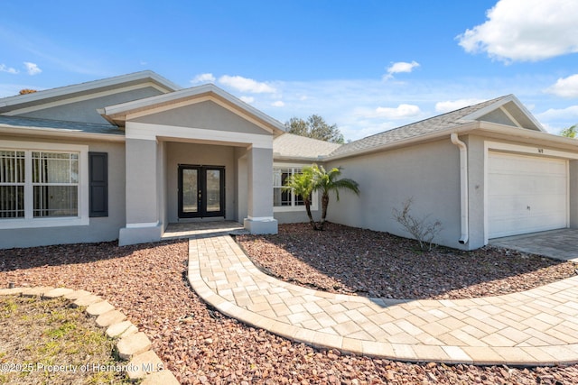 doorway to property with a garage and french doors