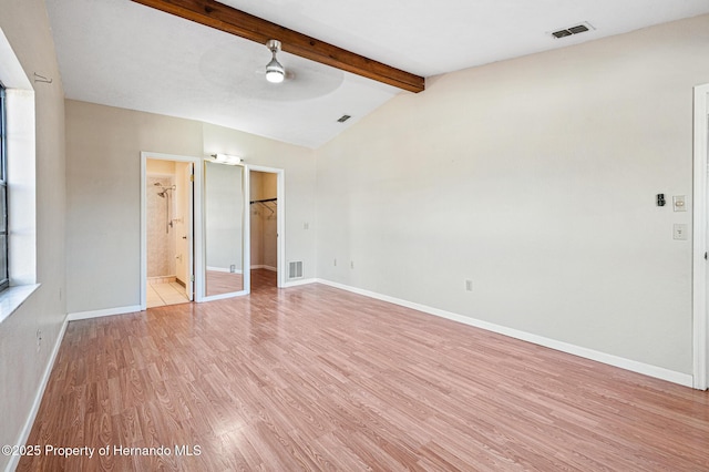 unfurnished bedroom featuring vaulted ceiling with beams, connected bathroom, and light hardwood / wood-style flooring