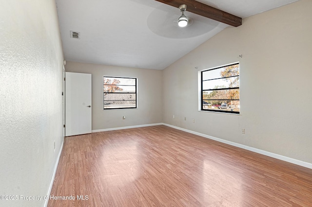 unfurnished room featuring lofted ceiling with beams, light hardwood / wood-style floors, a wealth of natural light, and ceiling fan