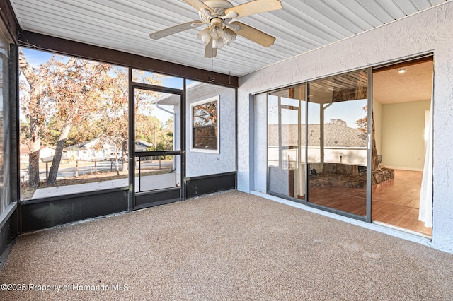 unfurnished sunroom featuring ceiling fan