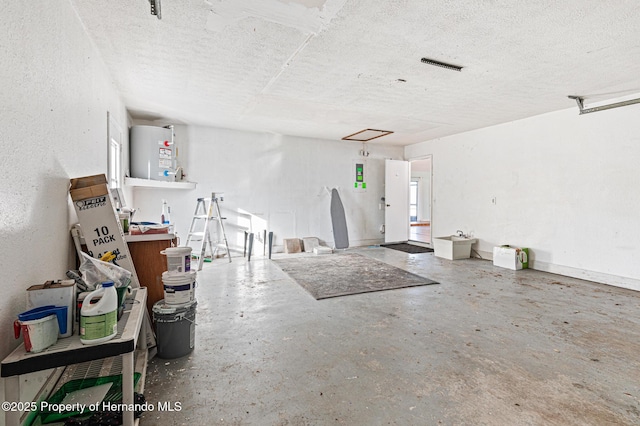 interior space with a textured ceiling and water heater