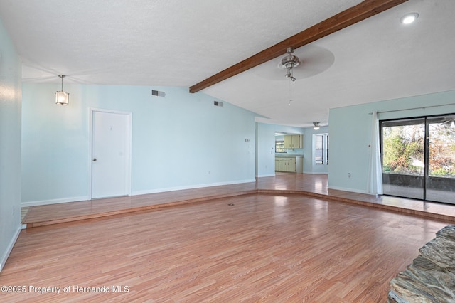 unfurnished living room featuring a textured ceiling, lofted ceiling with beams, light hardwood / wood-style floors, and ceiling fan