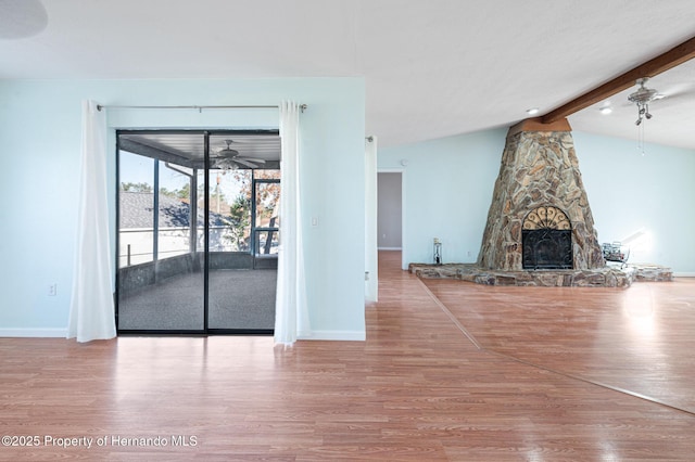 unfurnished living room with a fireplace, light wood-type flooring, lofted ceiling with beams, and ceiling fan