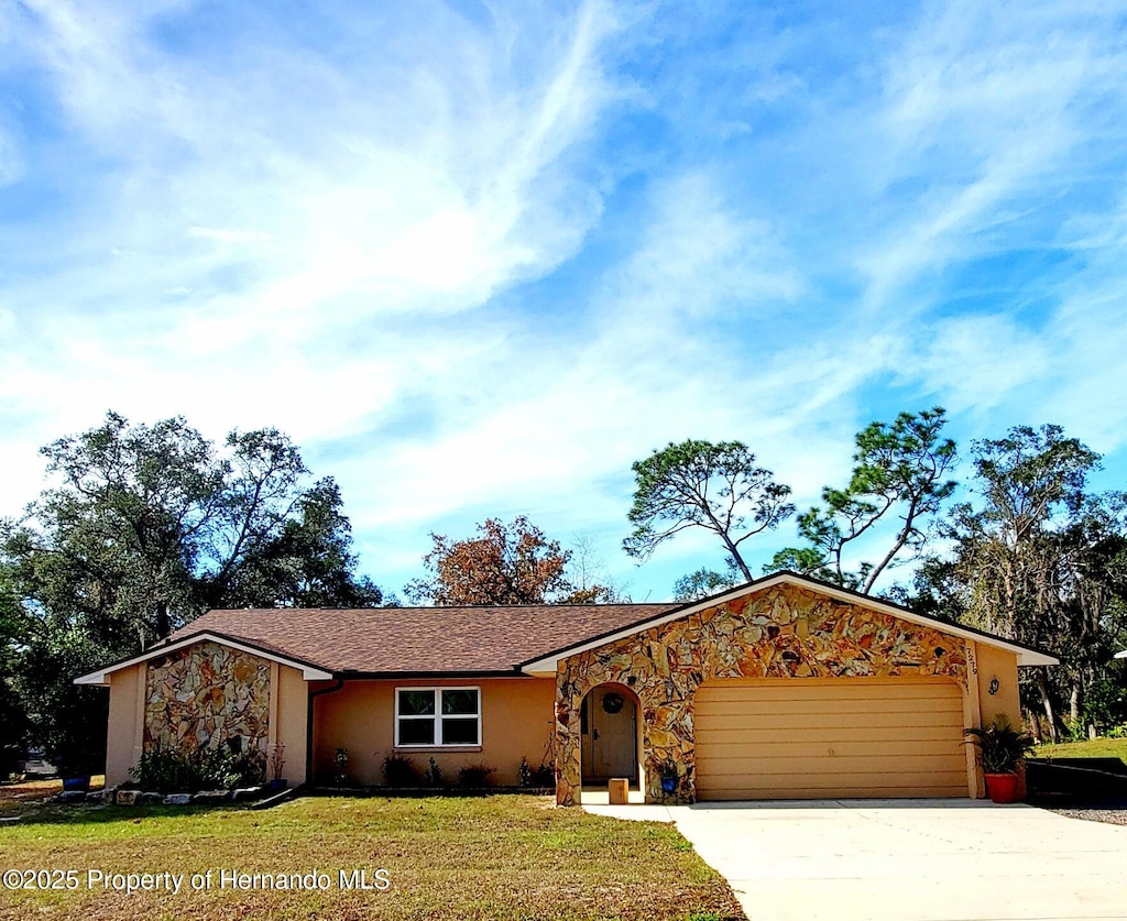 ranch-style house featuring a garage and a front yard