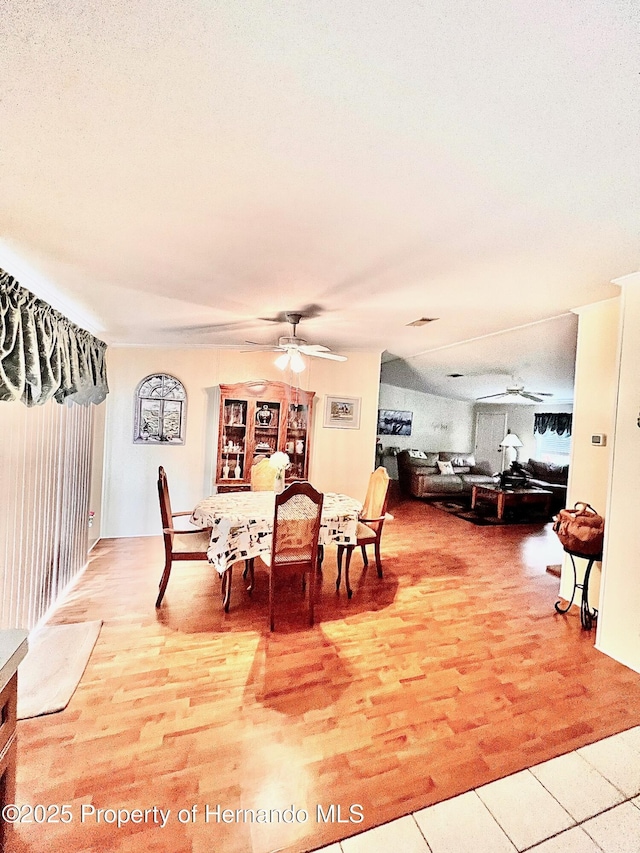 dining space with ceiling fan, hardwood / wood-style floors, and a textured ceiling