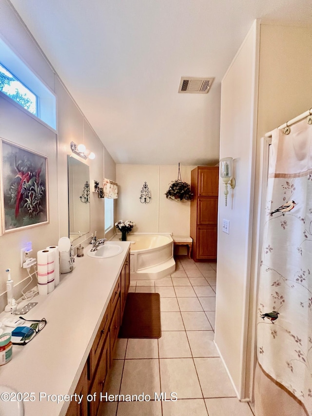 bathroom with tile patterned flooring, vanity, and separate shower and tub