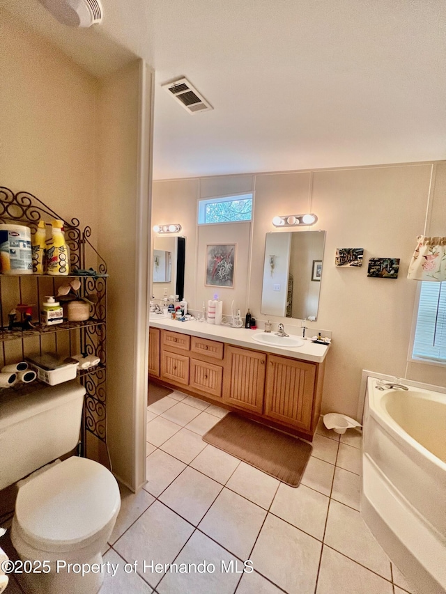 bathroom with tile patterned flooring, vanity, and plenty of natural light