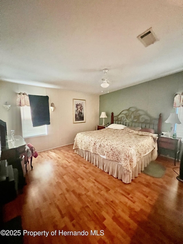 bedroom with a textured ceiling and hardwood / wood-style flooring