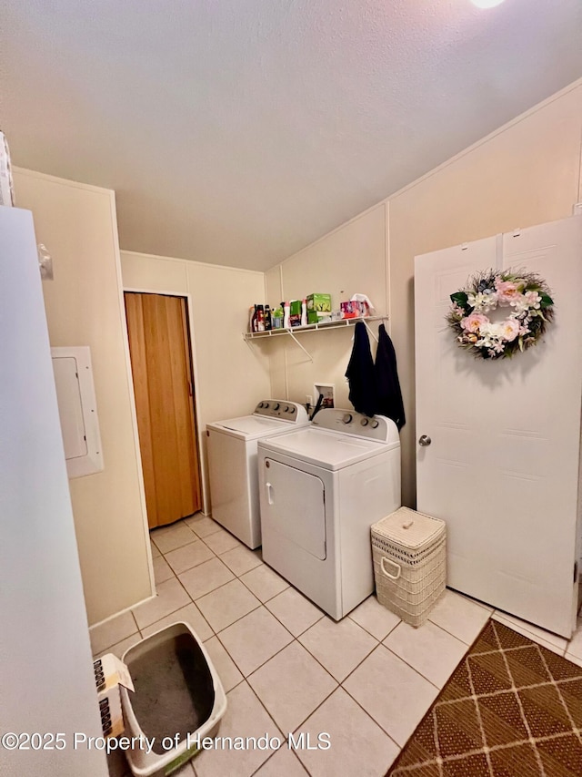 clothes washing area with separate washer and dryer and light tile patterned floors