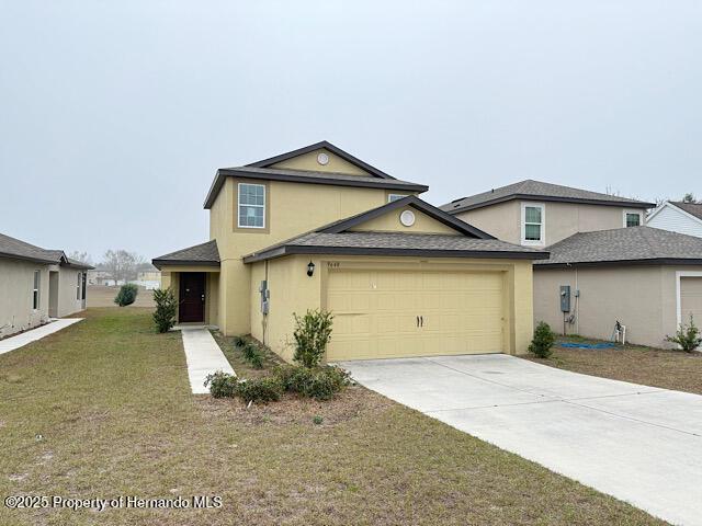 view of property featuring a garage and a front yard