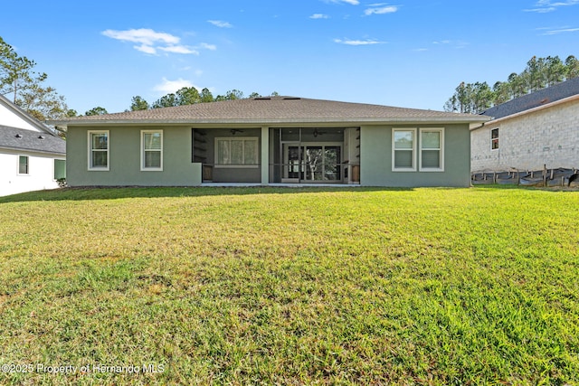 back of property featuring a lawn and a sunroom