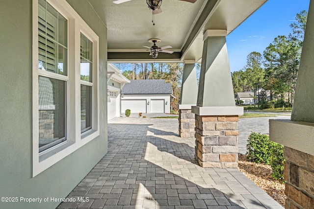 view of patio / terrace with a garage and ceiling fan