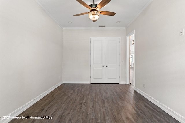 spare room featuring ceiling fan, dark wood-type flooring, and ornamental molding