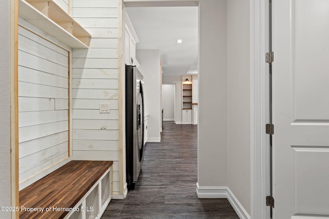 mudroom with dark hardwood / wood-style flooring and wooden walls