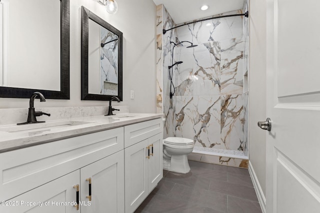 bathroom with tile patterned flooring, a tile shower, vanity, and toilet