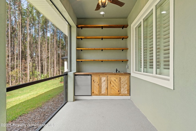 unfurnished sunroom with ceiling fan