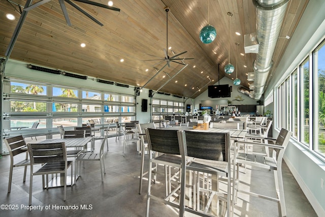 dining room with a healthy amount of sunlight, concrete floors, high vaulted ceiling, and wood ceiling