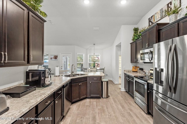 kitchen featuring lofted ceiling, sink, dark brown cabinets, light hardwood / wood-style floors, and stainless steel appliances