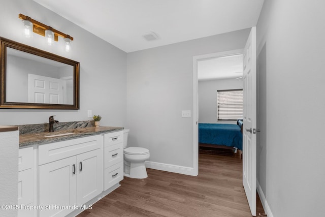 bathroom featuring vanity, hardwood / wood-style flooring, and toilet