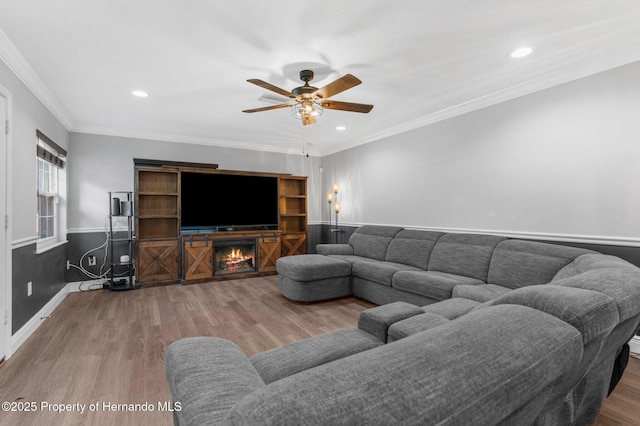 living room with crown molding, ceiling fan, and wood-type flooring