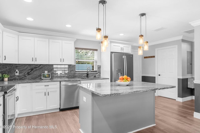 kitchen with white cabinets, a center island, sink, and appliances with stainless steel finishes