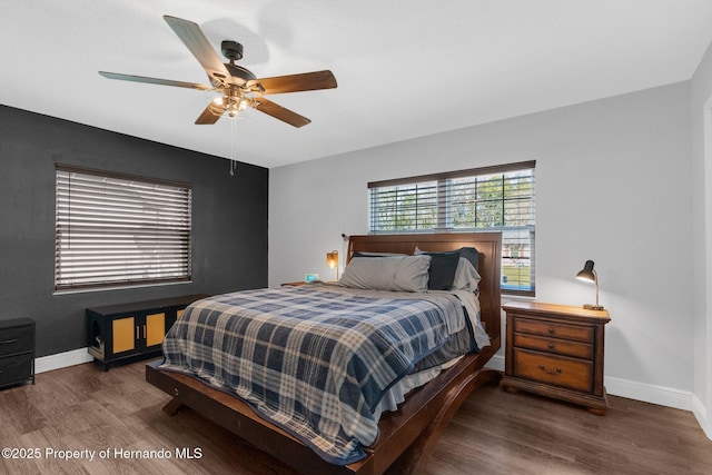 bedroom with dark hardwood / wood-style flooring and ceiling fan