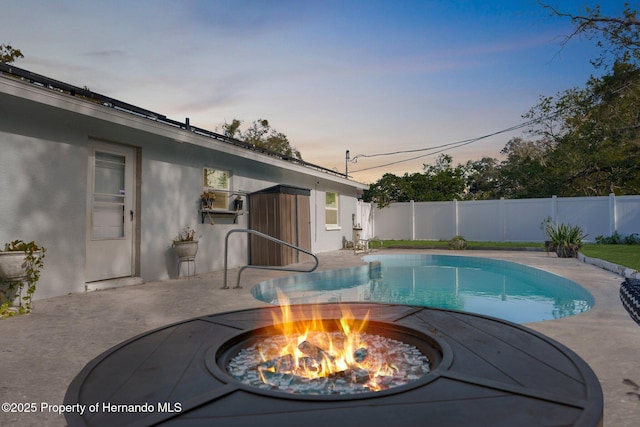 pool at dusk with a fire pit