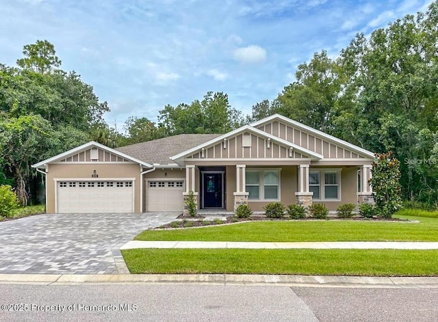 craftsman house featuring a garage and a front lawn