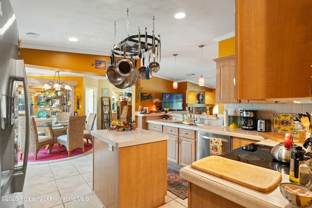 kitchen featuring vaulted ceiling, appliances with stainless steel finishes, sink, ornamental molding, and kitchen peninsula