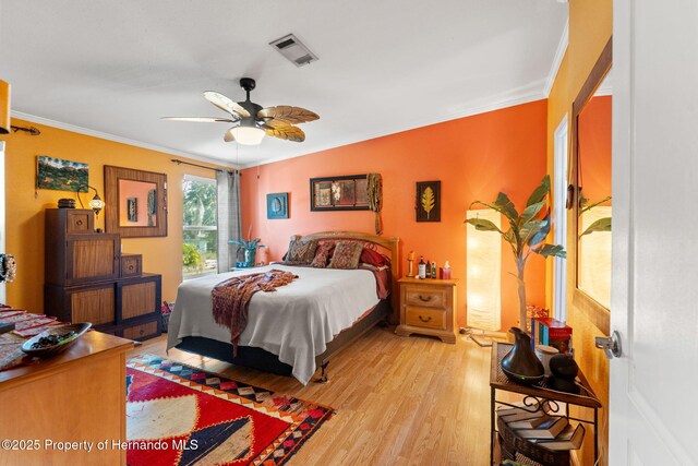 bedroom with ornamental molding, ceiling fan, and light hardwood / wood-style flooring